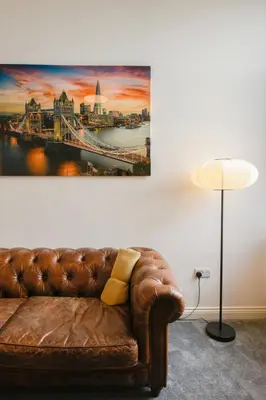 a couch in a room with a painting on the wall at Suite in the center of Great Harwood in Great Harwood