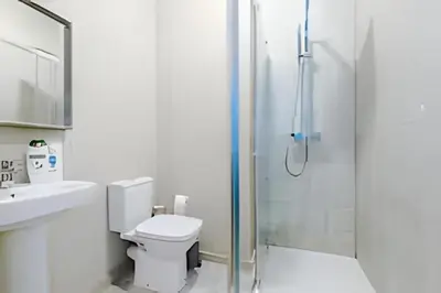 a bathroom with a shower and a toilet and a sink at 1 Bedroom Apartment in Wigan Town Centre With Free Parking, by Short Term Digs Short Lets & Serviced Accommodation in Wigan