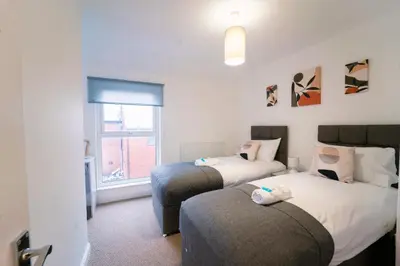 a bedroom with two beds and a window at Stylish Self Check In Wigan Town Centre Apartment with Fast WiFi Ideal for Long Stays and Contractor Stays in Wigan