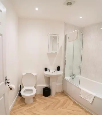 a white bathroom with a toilet and a sink at Stylish Self Check In Wigan Town Centre Apartment with Fast WiFi Ideal for Long Stays and Contractor Stays in Wigan