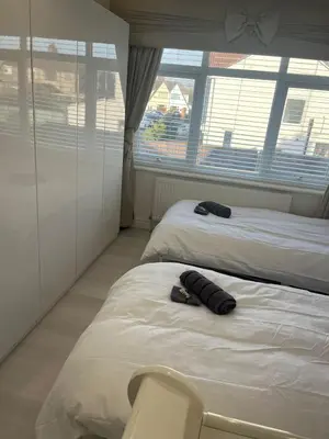two beds in a room with two large windows at Stylish Home Away From Home! 6 Minutes from Beach! in Wirral
