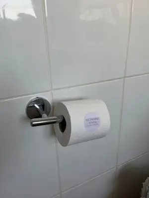 a roll of toilet paper on a bathroom wall at Stylish Home Away From Home! 6 Minutes from Beach! in Wirral