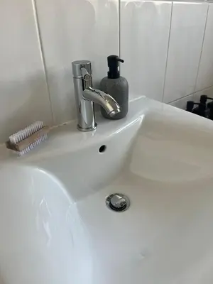 a bathroom sink with a soap dispenser on it at Stylish Home Away From Home! 6 Minutes from Beach! in Wirral