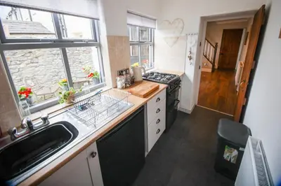 a kitchen with a sink and a stove and a window at Mill Cottage in Clitheroe