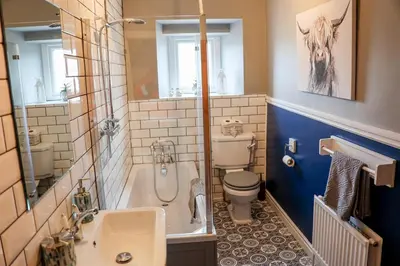 a bathroom with a tub and a toilet and a sink at Mill Cottage in Clitheroe