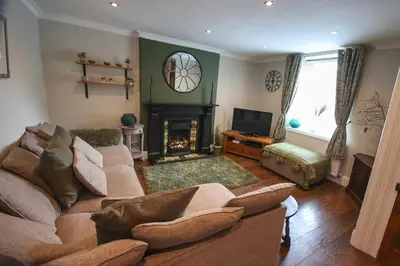 a living room with a couch and a fireplace at Mill Cottage in Clitheroe