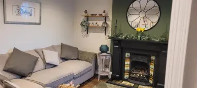 a living room with a couch and a fireplace at Mill Cottage in Clitheroe