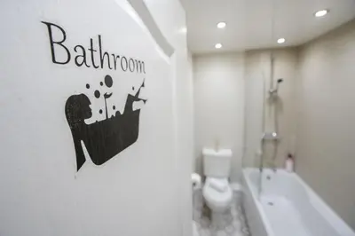 a bathroom with a toilet and a sign on the wall at Cozy Waterfront Apartment - Free Parking & Wi-Fi in Preston