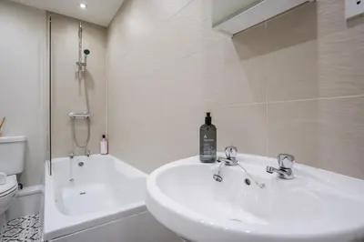 a bathroom with a sink and a toilet and a tub at Cozy Waterfront Apartment - Free Parking & Wi-Fi in Preston