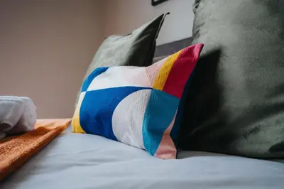 a colorful pillow sitting on top of a couch at Cozy Waterfront Apartment - Free Parking & Wi-Fi in Preston