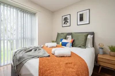 a bedroom with a large bed with towels on it at Cozy Waterfront Apartment - Free Parking & Wi-Fi in Preston
