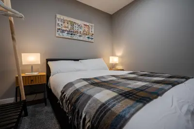 a bedroom with a bed and two lamps on tables at Dockside Escape By Royal Albert Dock in Liverpool