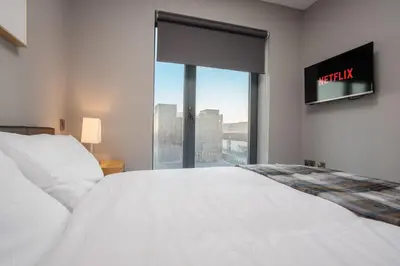 a bedroom with a white bed and a large window at Dockside Escape By Royal Albert Dock in Liverpool