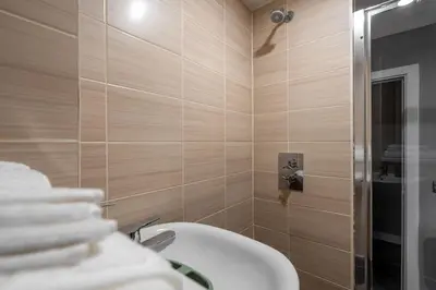 a bathroom with a white sink and a shower at Dockside Escape By Royal Albert Dock in Liverpool