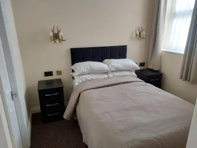 a bedroom with a large bed and two night stands at Edenfield Lodge in Blackpool