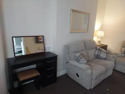 a living room with a chair and a mirror at Edenfield Lodge in Blackpool