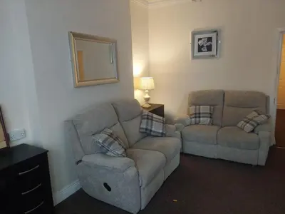 a living room with a couch and a chair at Edenfield Lodge in Blackpool