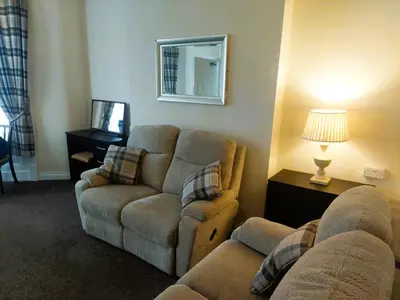 a living room with a couch and a chair at Edenfield Lodge in Blackpool
