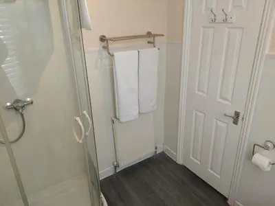 a bathroom with a towel rack and a white door at Edenfield Lodge in Blackpool