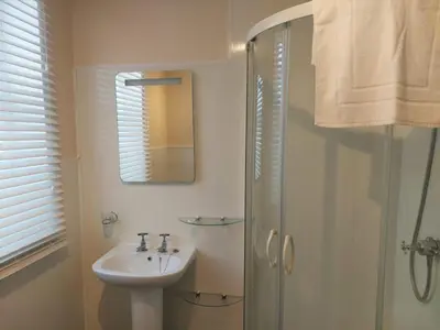 a bathroom with a sink and a shower with a mirror at Edenfield Lodge in Blackpool