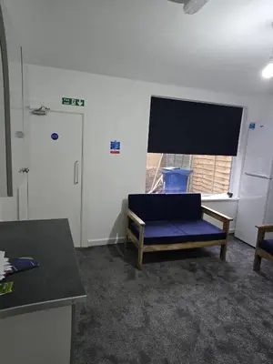 a room with a blue couch in front of a window at 167,ormskirk road in Wigan