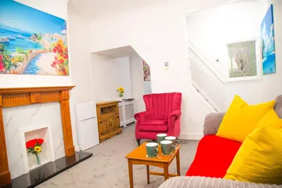 a living room with two chairs and a fireplace at Lucky Home 7 - Ideal for Trade & Family - 2 Bedrooms - 2 Beds - Max 4 Guests - Close to BAE, Docks, Lake District, Beaches in Barrow in Furness