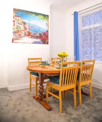 a dining room with a wooden table and chairs at Lucky Home 7 - Ideal for Trade & Family - 2 Bedrooms - 2 Beds - Max 4 Guests - Close to BAE, Docks, Lake District, Beaches in Barrow in Furness