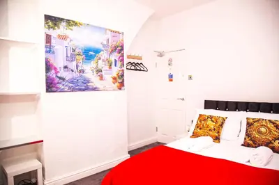 a bedroom with a red bed and a painting on the wall at Lucky Home 7 - Ideal for Trade & Family - 2 Bedrooms - 2 Beds - Max 4 Guests - Close to BAE, Docks, Lake District, Beaches in Barrow in Furness