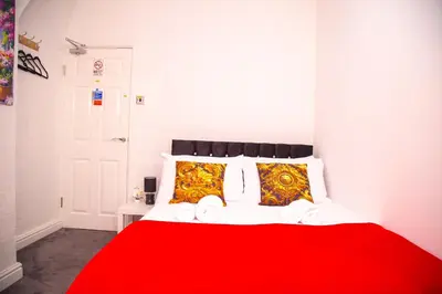 a red and white bed with a red blanket and pillows at Lucky Home 7 - Ideal for Trade & Family - 2 Bedrooms - 2 Beds - Max 4 Guests - Close to BAE, Docks, Lake District, Beaches in Barrow in Furness