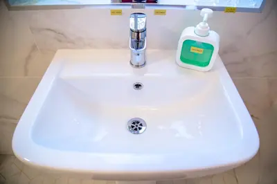 a white sink with a bottle of soap on it at Lucky Home 15 - Ideal for Trade & Family - 2 Bedrooms - 2 Beds - Max 4 Guests - Close to BAE, Docks, Lake District, Beaches in Barrow in Furness