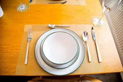 a table with a white plate and fork and knife at Lucky Home 15 - Ideal for Trade & Family - 2 Bedrooms - 2 Beds - Max 4 Guests - Close to BAE, Docks, Lake District, Beaches in Barrow in Furness