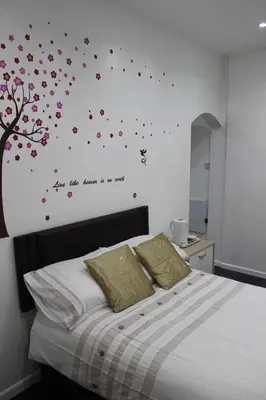 a bedroom with a bed with flowers and a tree at The Moray House in Blackpool