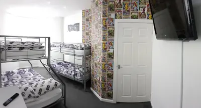 a room with bunk beds and a tv and a door at The Moray House in Blackpool
