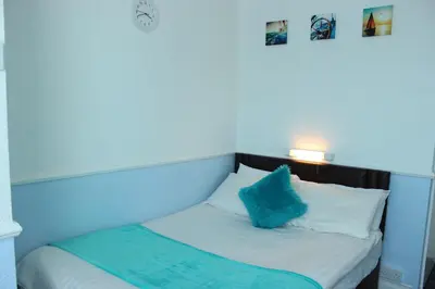 a small bed with a blue pillow on it at The Moray House in Blackpool