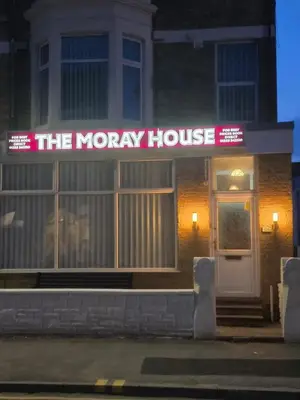 a moryory house with a neon sign in front of it at The Moray House in Blackpool