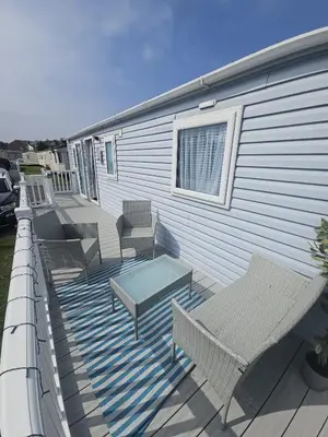 a deck with chairs and a table on a house at Caravan to Hire - CalaGran Fleetwood Blackpool in Fleetwood