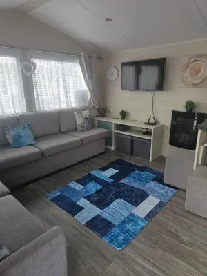a living room with a couch and a tv at Caravan to Hire - CalaGran Fleetwood Blackpool in Fleetwood