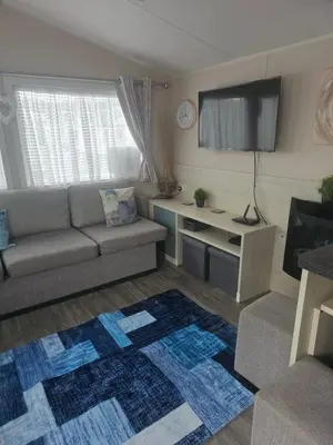a living room with a couch and a flat screen tv at Caravan to Hire - CalaGran Fleetwood Blackpool in Fleetwood