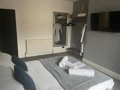 a bedroom with a bed with towels on it at Flat2 large modern King Bed Flat, private bathroom Ryan's place in Walton on the Hill