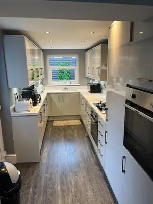a kitchen with white cabinets and a sink and a window at Flat2 large modern King Bed Flat, private bathroom Ryan's place in Walton on the Hill
