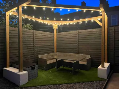 a picnic table under a pergola with lights at Flat2 large modern King Bed Flat, private bathroom Ryan's place in Walton on the Hill