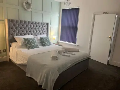 a bedroom with a large bed with a large headboard at Flat1 Large modern King Bed flat, private bedroom Ryan's place in Walton on the Hill