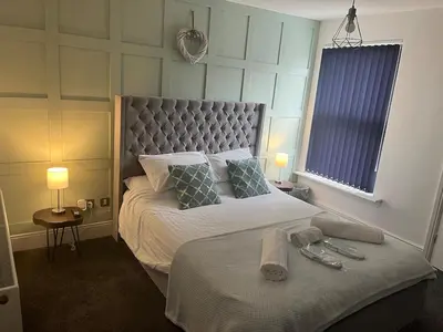 a bedroom with a large bed with a large headboard at Flat1 Large modern King Bed flat, private bedroom Ryan's place in Walton on the Hill