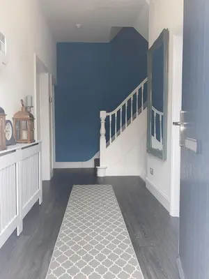 a hallway with a blue wall and a staircase at Flat1 Large modern King Bed flat, private bedroom Ryan's place in Walton on the Hill