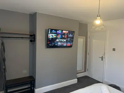 a room with a flat screen tv on the wall at Flat1 Large modern King Bed flat, private bedroom Ryan's place in Walton on the Hill