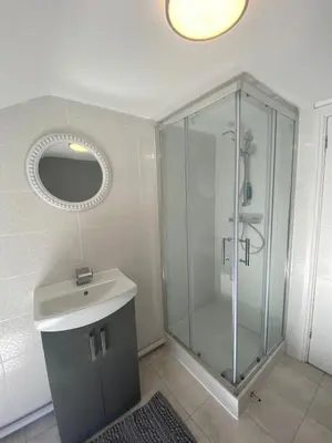 a bathroom with a shower with a sink and a mirror at Flat3 large modern king Bed flat private bathroom ryan's place in Walton on the Hill
