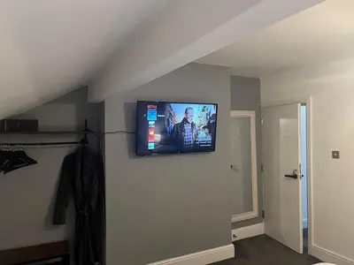 a flat screen tv on the wall of a room at Flat3 large modern king Bed flat private bathroom ryan's place in Walton on the Hill