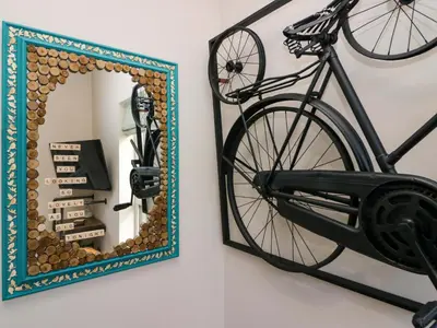 a bike hanging on a wall next to a mirror at Elderflower Lodge in Grange Over Sands