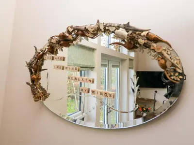 a mirror hanging on a wall with signs on it at Elderflower Lodge in Grange Over Sands