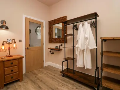 a bathroom with a towel rack and a mirror at Elderflower Lodge in Grange Over Sands